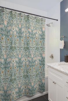 a bathroom with a shower curtain that has a flower pattern on it, along with a sink and toilet