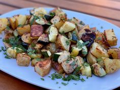 a white plate topped with potatoes and herbs