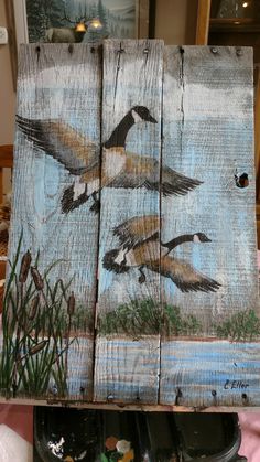 three birds painted on wooden planks sitting on a table