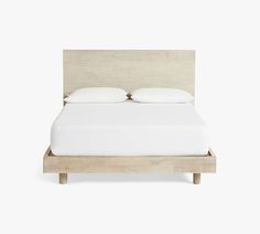 a bed with two pillows on top of it and a wooden frame around the headboard