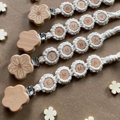 four wooden name tags attached to white string with clovers and flowers in the background