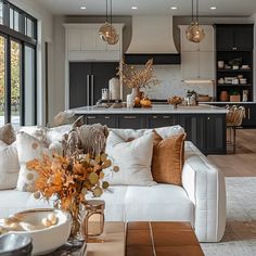 a living room filled with furniture next to a kitchen and breakfast nook area on top of a hard wood floor