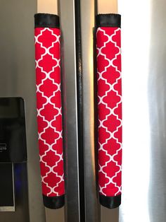 two red and white umbrellas hanging on the side of a metal refrigerator freezer