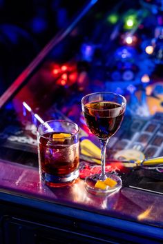 two glasses filled with liquid sitting on top of a table next to a computer keyboard