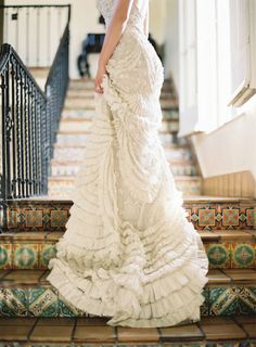 a woman in a white dress standing on some stairs