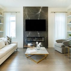 a living room filled with furniture and a flat screen tv mounted on the wall above a fireplace