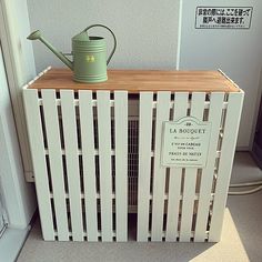 a wooden crate with a watering can on top