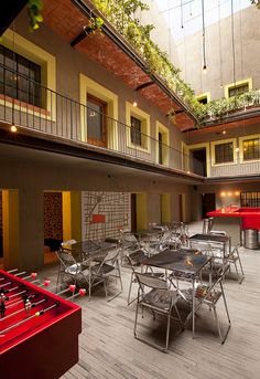 an indoor dining area with tables, chairs and foosballs on the floor