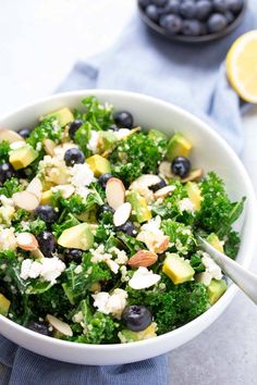 a salad with blueberries, avocado, almonds and feta cheese