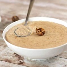 a white bowl filled with oatmeal on top of a wooden table