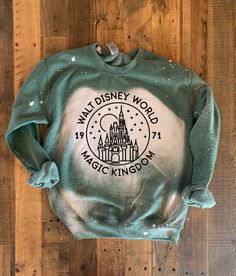 the disneyland world magic kingdom sweatshirt on a wooden floor