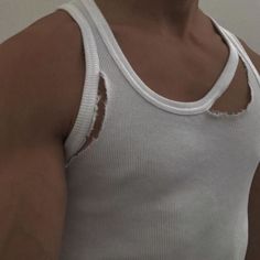 a man wearing a white tank top with holes in the front and back of his shirt