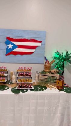 a table topped with lots of desserts next to a flag painted on the wall