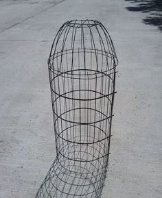 a metal bird cage sitting on the ground