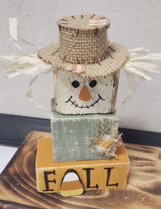 a wooden block with a scarecrow on top and the word foll painted on it