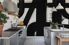 the kitchen is decorated with black and white wallpaper, potted plants on the counter