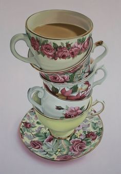 three tea cups and saucers stacked on top of each other with pink roses painted on them