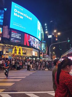 people are crossing the street at night in times square