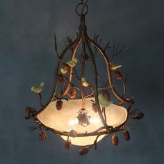 a chandelier hanging from the ceiling with pine cones and branches attached to it