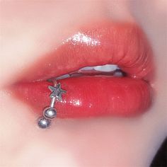 a close up view of a person's lips and nose piercing