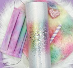 the unicorn glitter tumbler is next to some other items