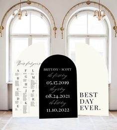 two black and white wedding signs in front of windows