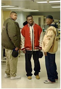 three young men standing next to each other in a room with white walls and flooring