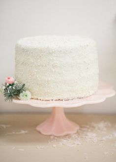 a white cake sitting on top of a pink plate