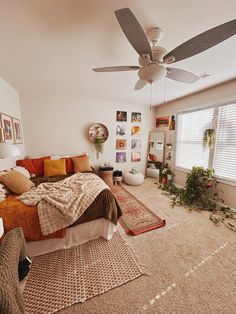 a bed room with a neatly made bed and a ceiling fan in the middle of it