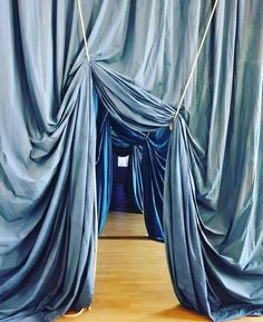 a room with blue drapes hanging from the ceiling