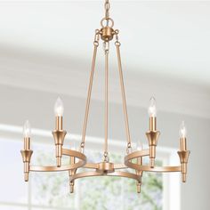 a chandelier with five lights hanging from it's center, in an empty room