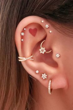 a woman's ear with three different piercings