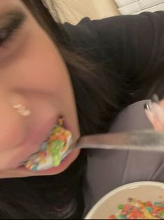 a woman eating cereal with a spoon in her mouth