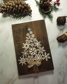 a wooden cutting board decorated with white snowflakes and pine cones on a table