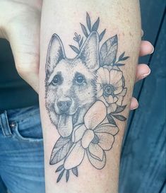 a woman's arm with a dog and flowers on it