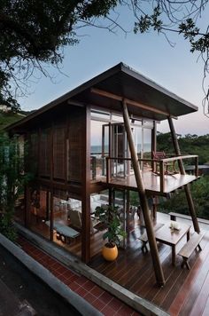 a wooden house sitting on top of a lush green hillside