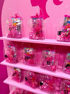 pink shelves filled with lots of different types of candy in plastic bags on top of each shelf