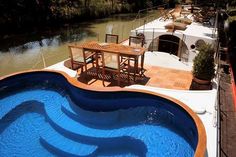 an above ground swimming pool in the middle of a patio with table and chairs next to it