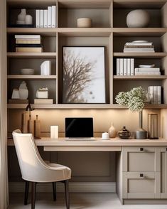 a desk with a laptop and some books on it in front of a bookcase