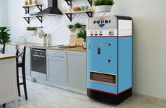 a blue machine sitting in the middle of a kitchen next to a stove top oven