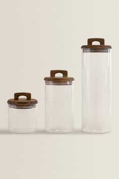 three glass containers with wooden lids