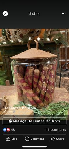 a glass jar filled with cinnamons sitting on top of a wooden table next to a christmas tree