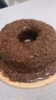 a chocolate frosted donut sitting on top of a wooden plate