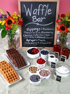 the waffle bar is set up with flowers in vases and other food items