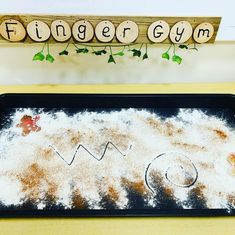 a wooden sign that says finger gym on it next to some powdered sugar and cinnamon