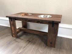 a wooden table with two bowls of food on it and a dog bowl in the middle