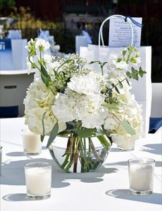 a vase filled with white flowers sitting on top of a table