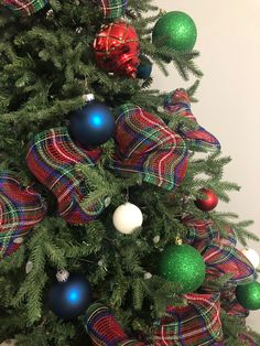 a christmas tree decorated with plaid ribbon and ornaments