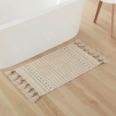 a bath tub sitting on top of a wooden floor next to a rug and chair