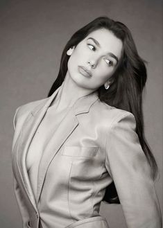 a woman in a suit poses for a black and white photo